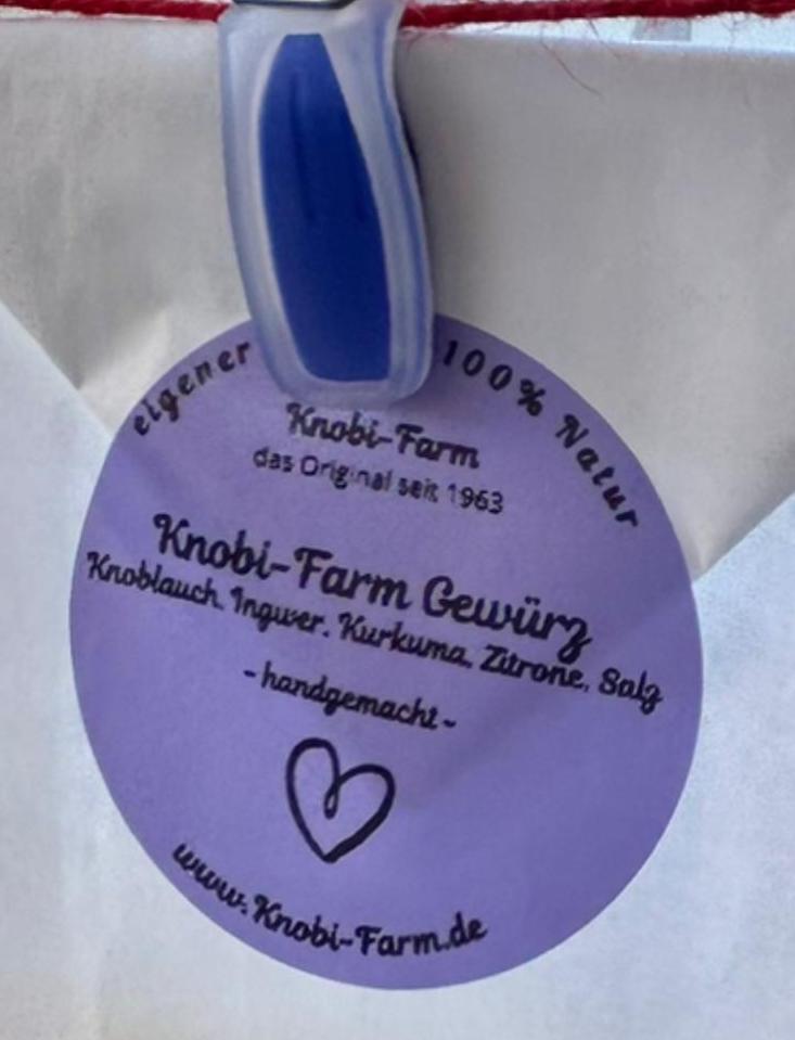 Nahaufnahme des lila Etiketts Knobi-Farm Gewürz mit den Zutaten Knoblauch, Ingwer, Kurkuma, Zitrone und Salz