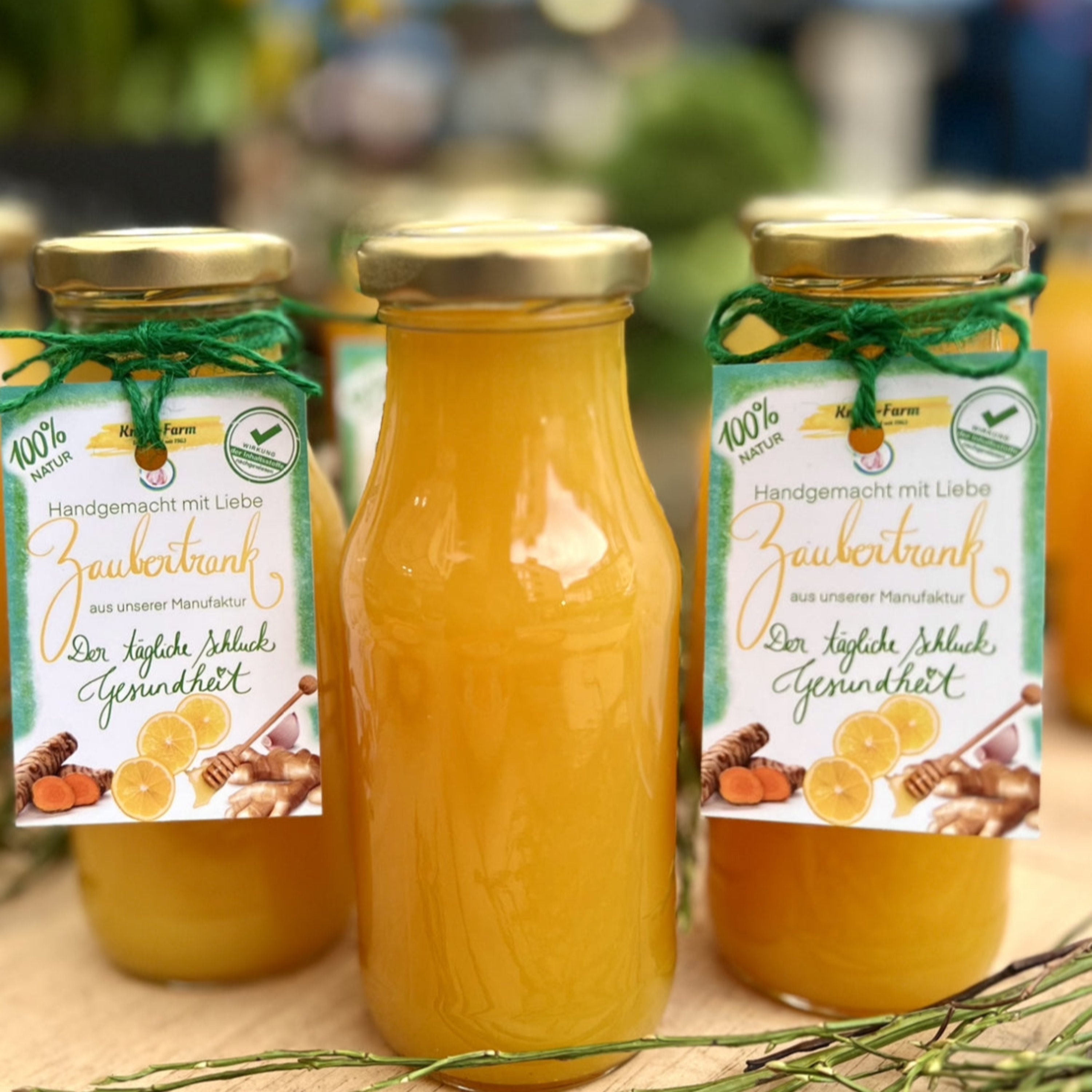 Drei Flaschen Zaubertrank mit goldgelbem Inhalt und handbeschrifteten Anhängern auf einem Holztisch